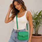 Women's emerald green faux leather shoulder bag with a structured silhouette, magnetic flap closure and adjustable shoulder strap.
