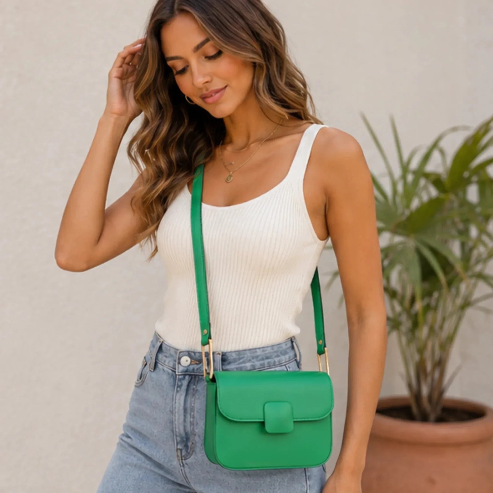 Women's emerald green faux leather shoulder bag with a structured silhouette, magnetic flap closure and adjustable shoulder strap.