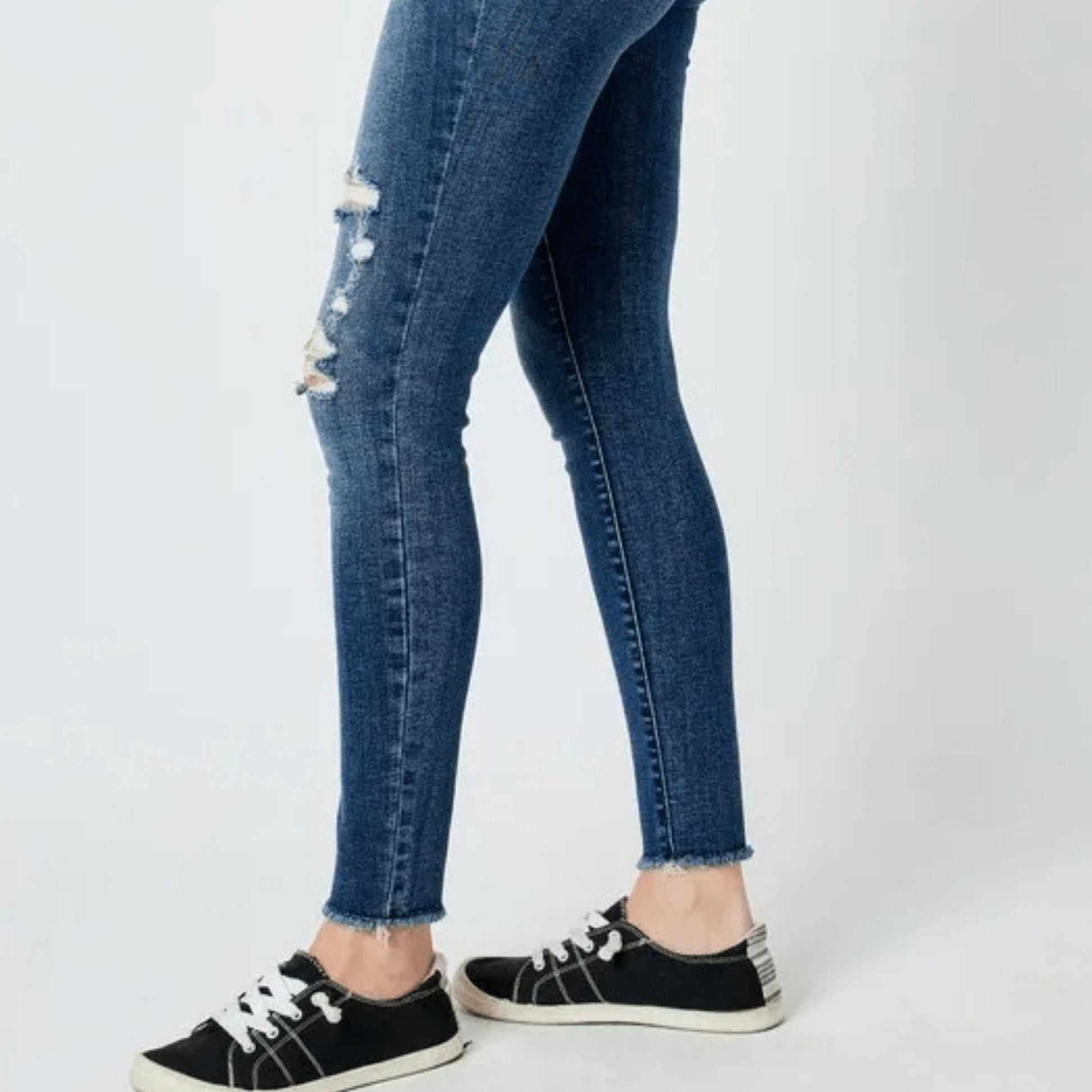 Side profile showcasing the skinny fit and knee distressing.