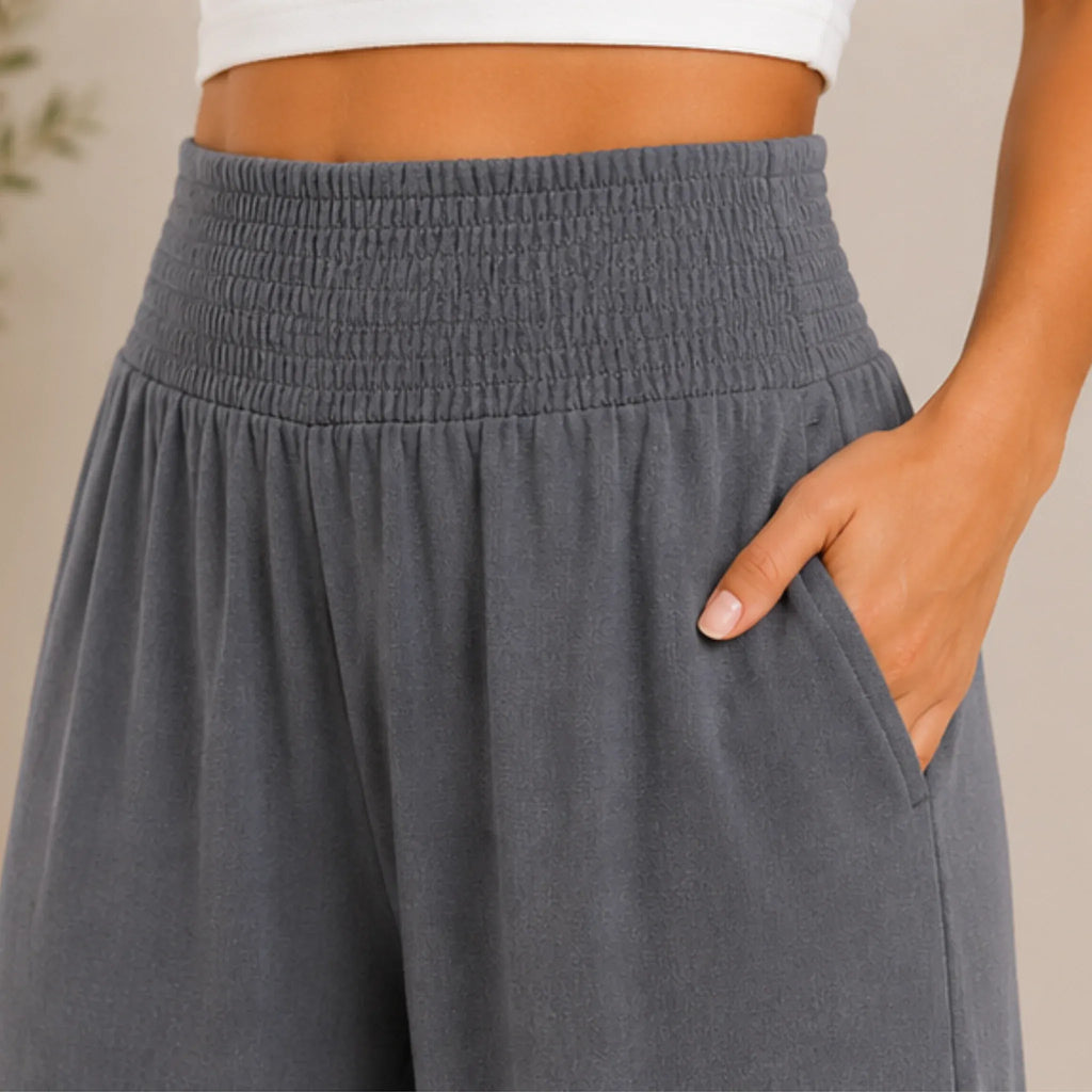 Close-up of slate blue grey lightweight high-waisted wide-leg lounge pants featuring a smocked waistband, soft fabric, and side pocket.