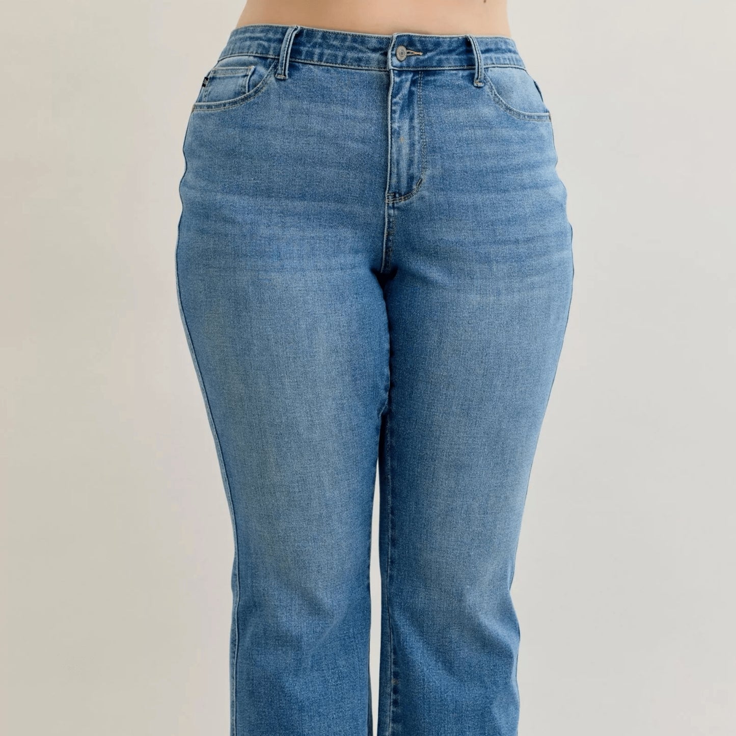 Detail view of the mid-rise waist and slim bootcut leg on Judy Blue jeans.