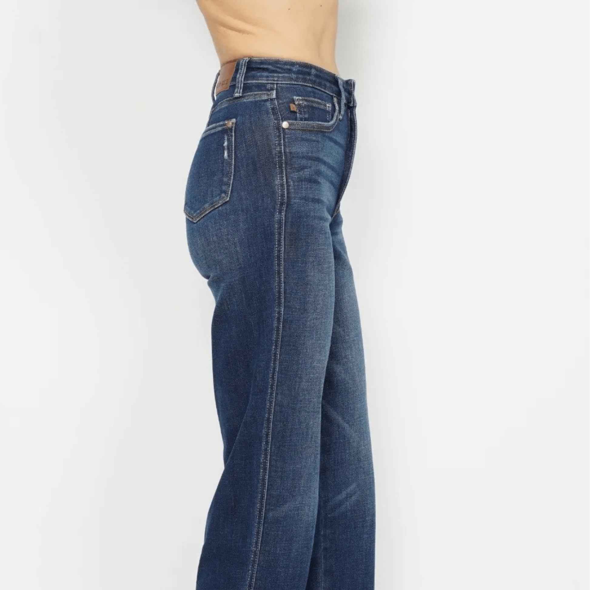 Close-up of the smoothing tummy control waistband on dark wash jeans.