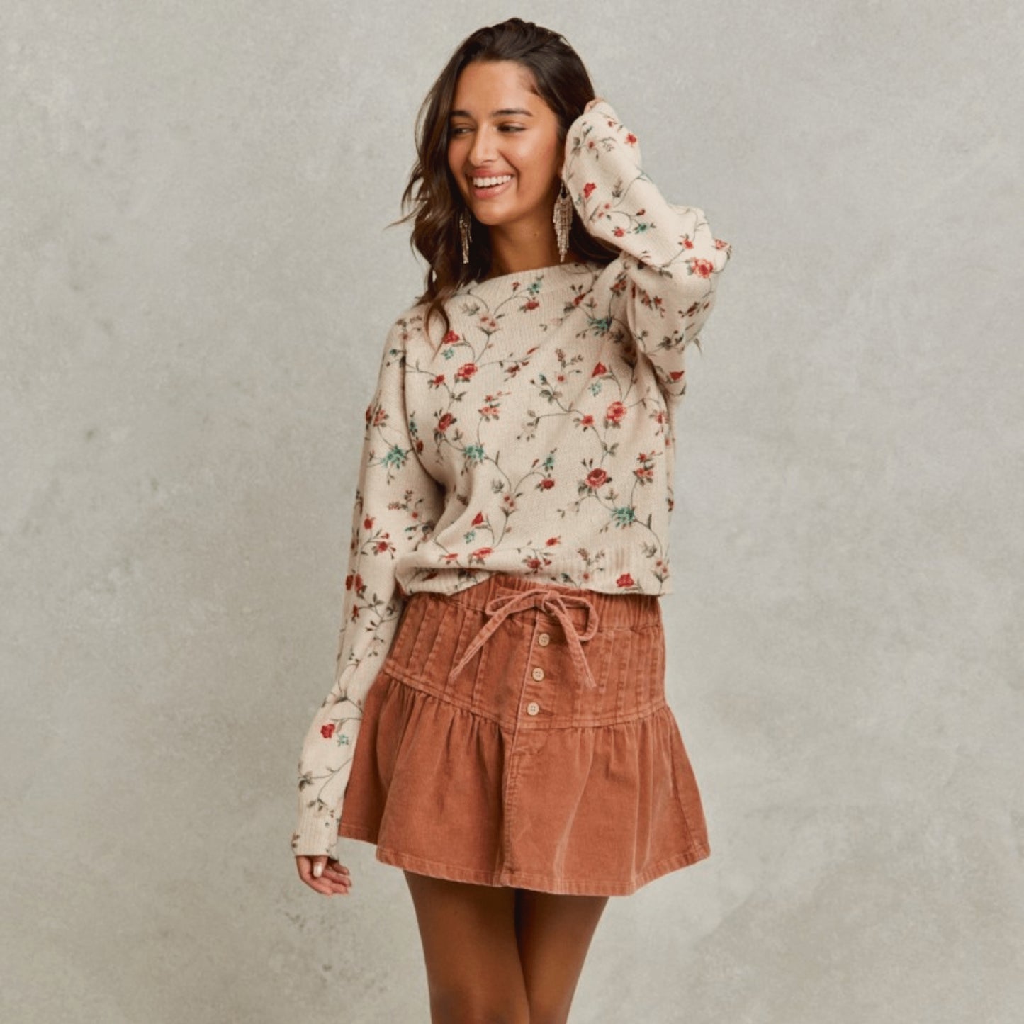 Frontal display of a woman wearing the SO ME rust mineral wash corduroy mini skirt.