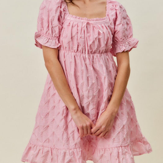 Close-up of the delicate ruching on the bust of the SO ME pink woven dress.