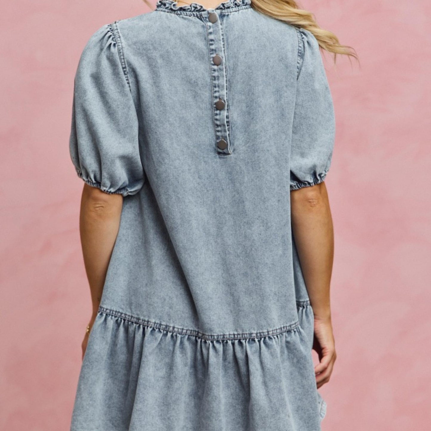 Back view of the SO ME light wash tiered denim mini dress.