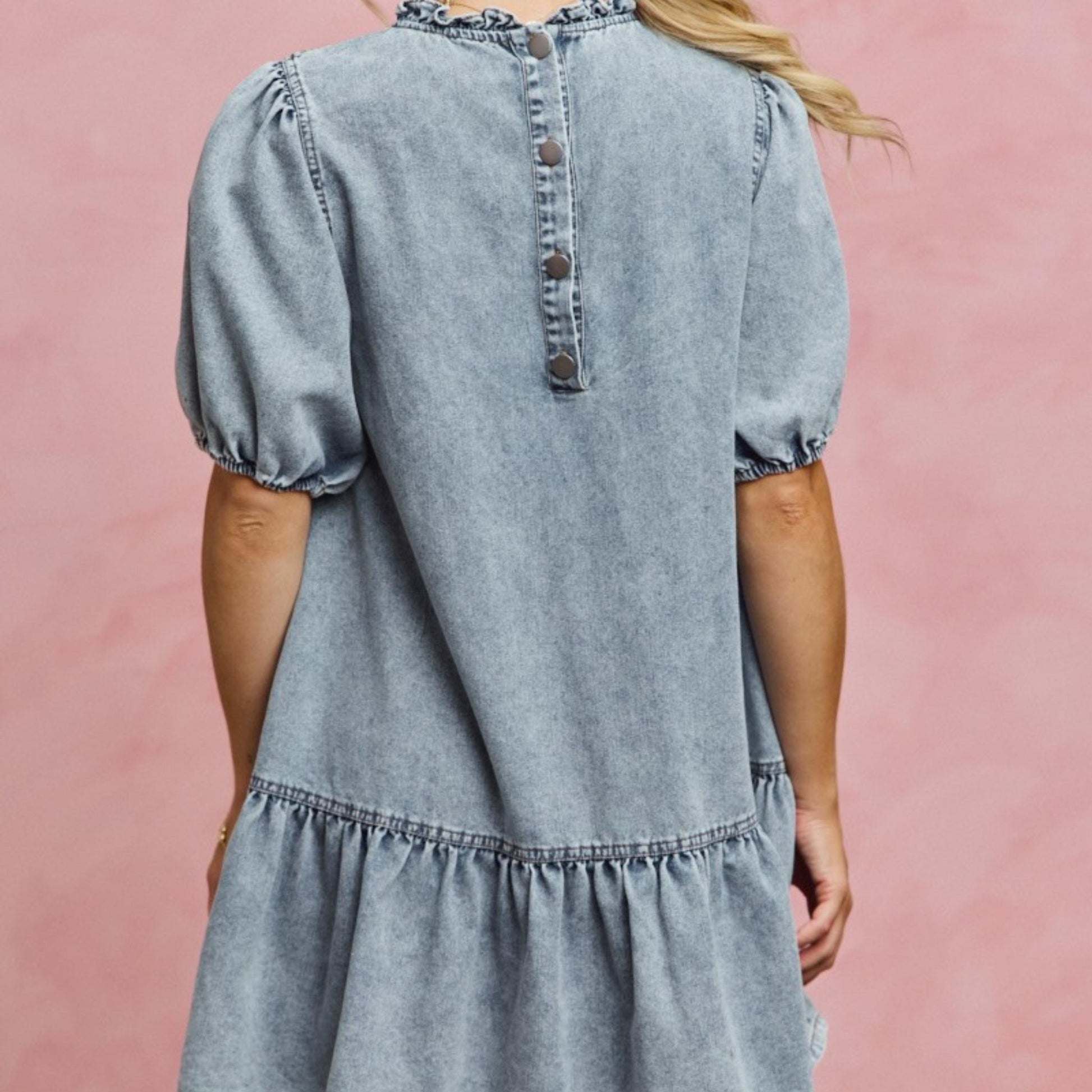 Back view of the SO ME light wash tiered denim mini dress.