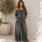 Woman wearing the Solazura Classic Wide Leg Denim Jumpsuit in charcoal grey featuring a vintage washed finish, button-front closure, oversized pockets, and relaxed wide-leg silhouette.