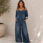 Woman wearing the Solazura Classic Wide Leg Denim Jumpsuit in navy blue with a relaxed fit, button-front design, adjustable buckle straps, oversized pockets, and wide-leg silhouette.