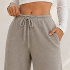 Close-up of khaki wide-leg pants showing drawstring waist, ribbed texture, and pocket