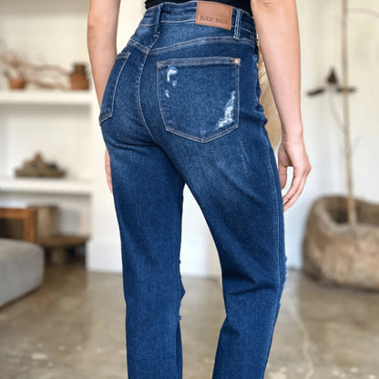 Close-up view of the knee distressing on straight-leg dark wash denim.