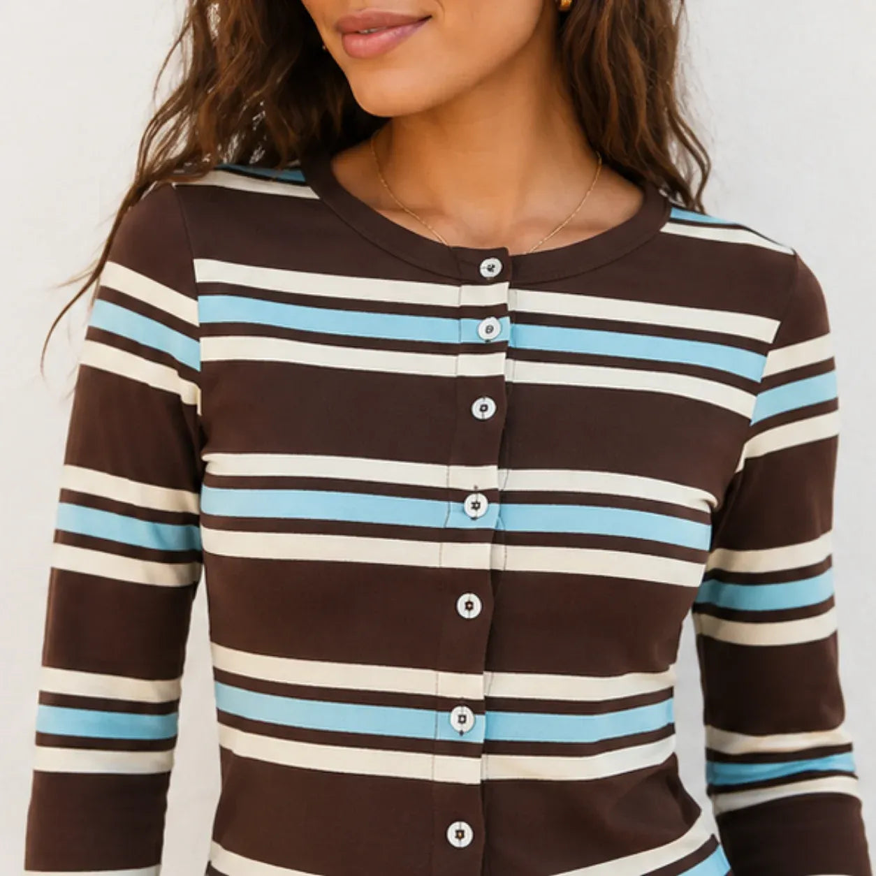 Close-up of the striped knit button-up top showing the button front and stripe detail