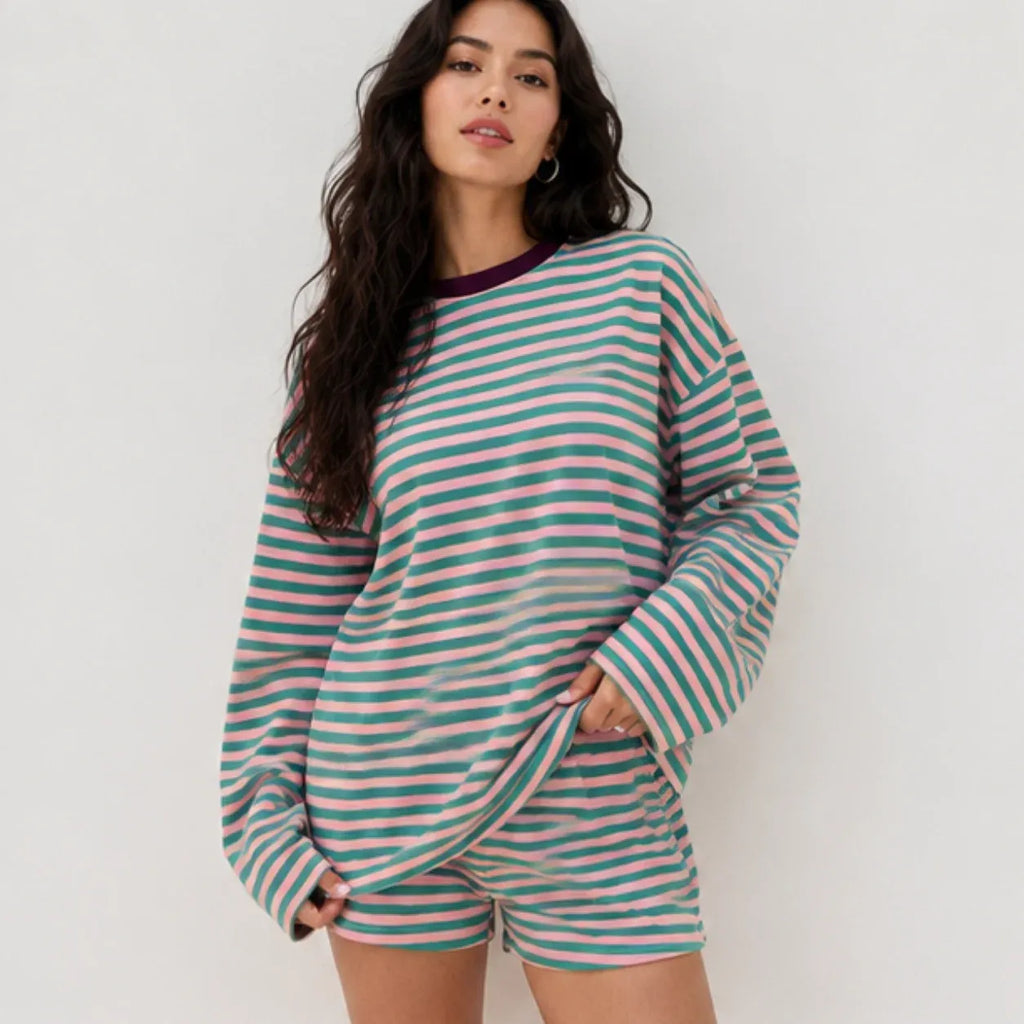 Woman wearing the pink and teal green striped relaxed long-sleeve top and matching shorts set front view