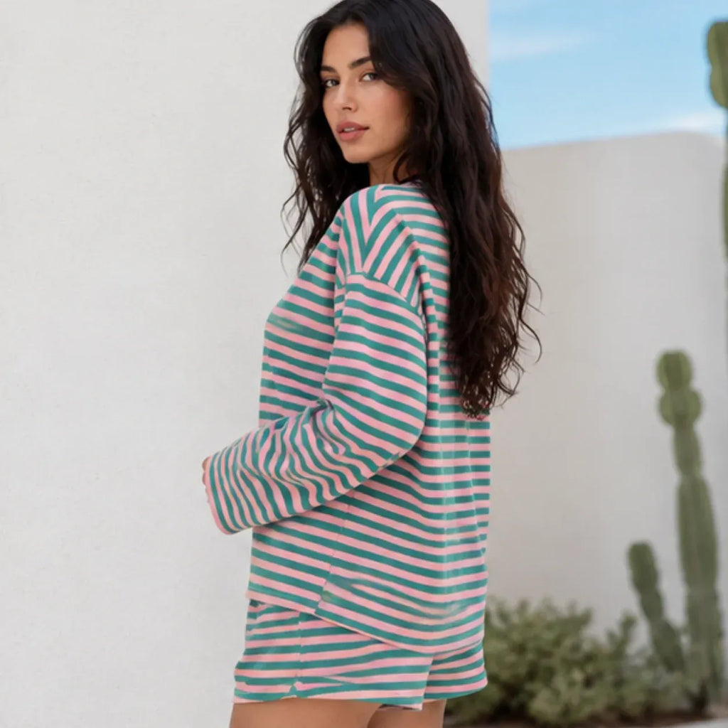 Side view of woman wearing pink and green striped relaxed two-piece lounge shorts set
