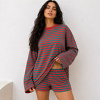 Woman wearing bold red and teal green striped long-sleeve top and matching shorts set