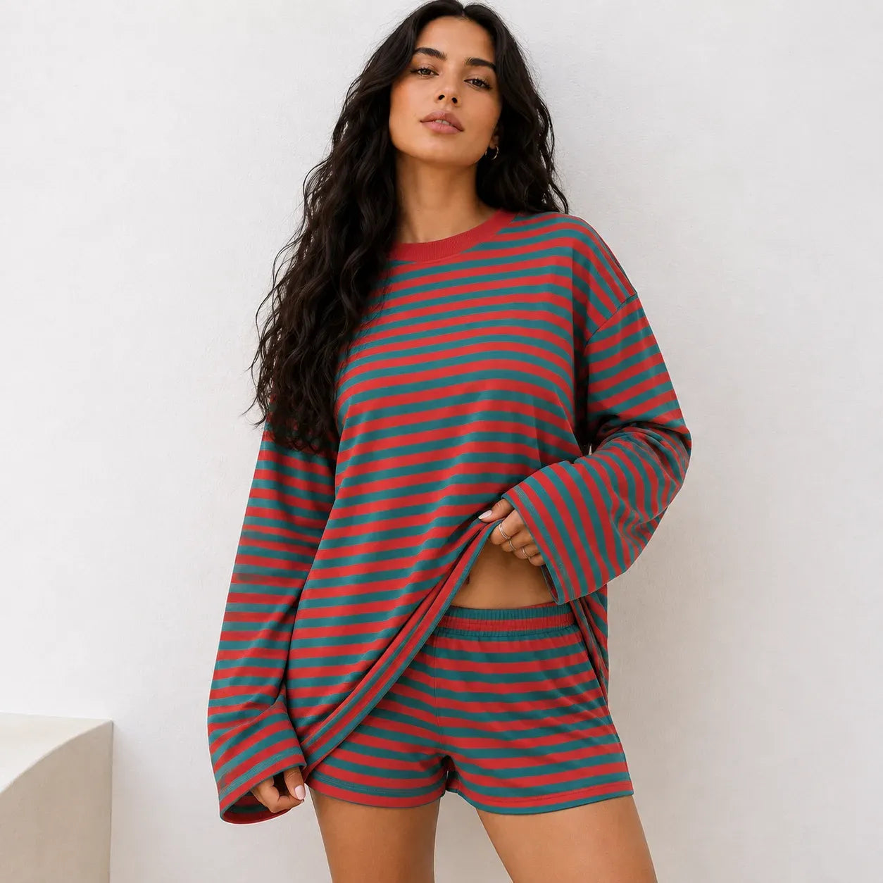 Woman wearing bold red and teal green striped long-sleeve top and matching shorts set