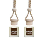 Two Tobacco Vanille reed diffusers with clear glass bottles, light wood reeds, and a beige braided hanging cord on a white background.