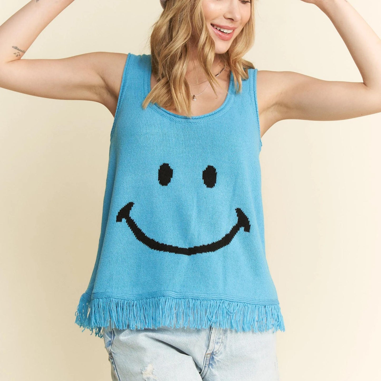 Detailed view of the turquoise smiley face tank and denim shorts.
