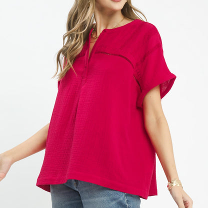 Side profile of the red textured gauze blouse showing the relaxed, breezy fit.
