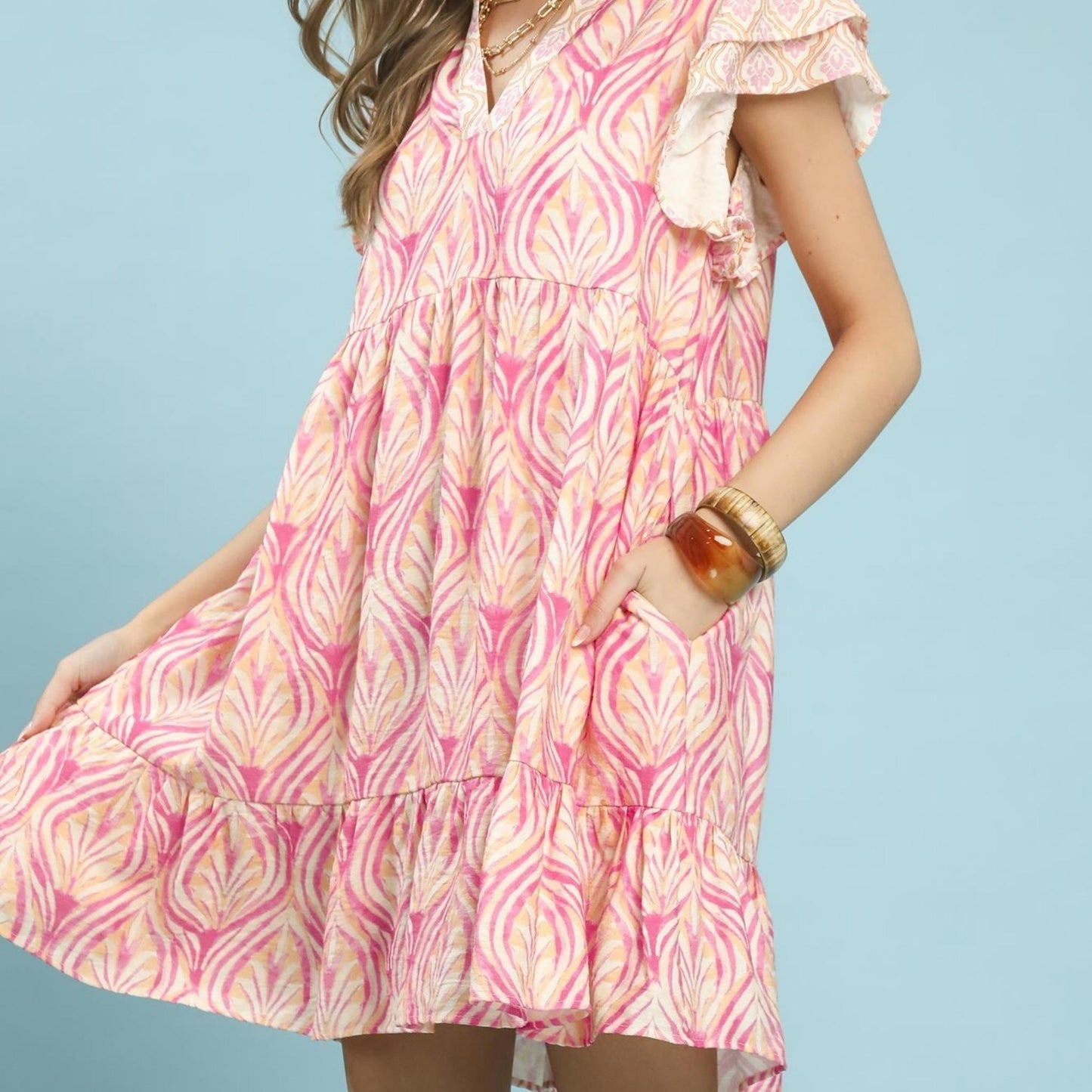 Side view highlighting the lightweight movement and flutter sleeve detail of the mini dress.