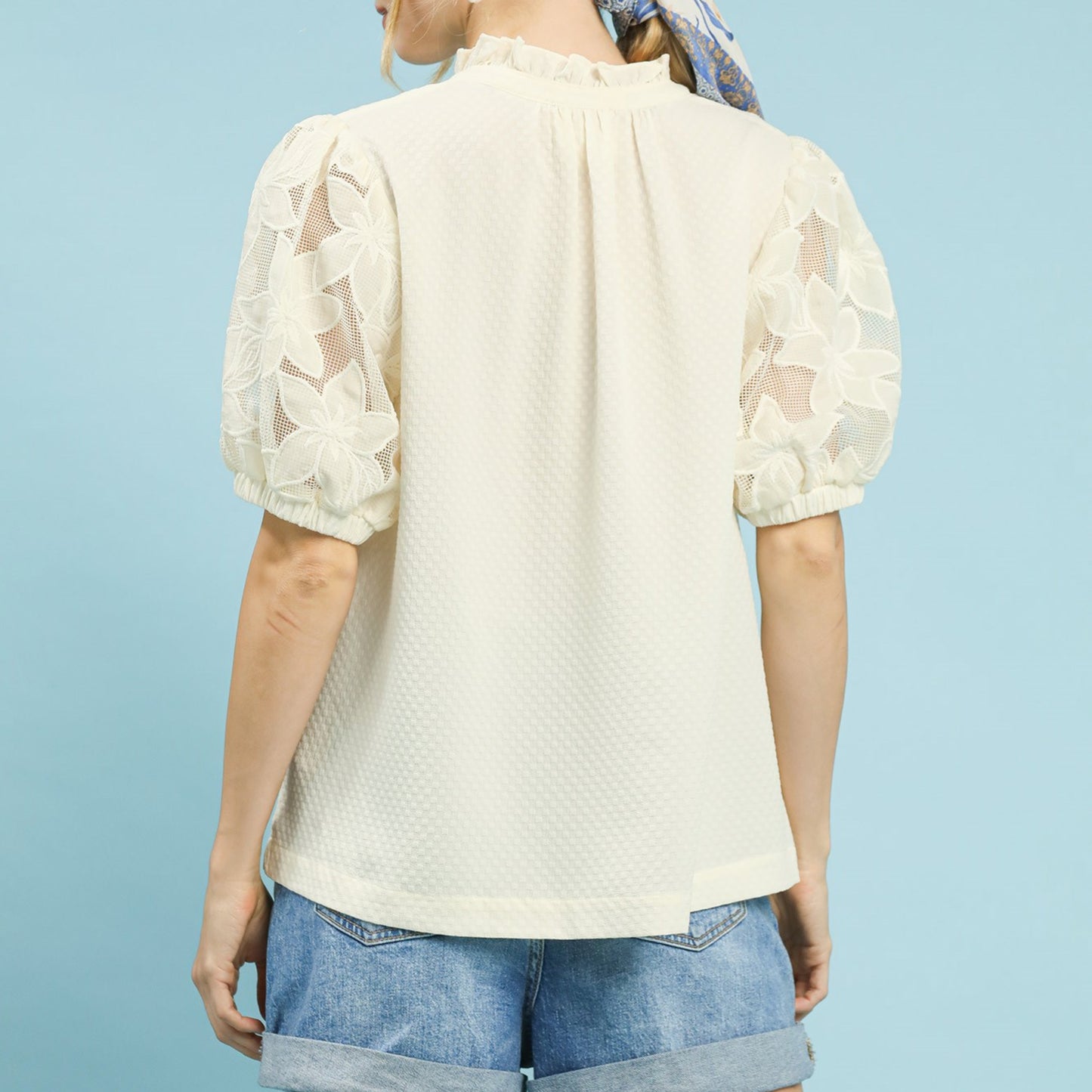 Back view of the textured cream blouse showing the relaxed and flowy silhouette.
