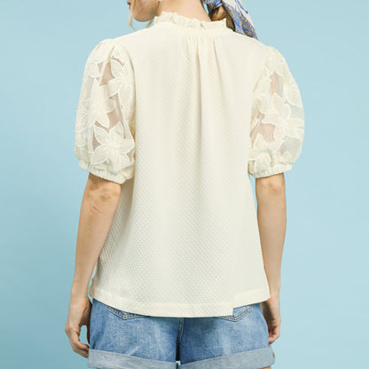 Back view of the textured cream blouse showing the relaxed and flowy silhouette.