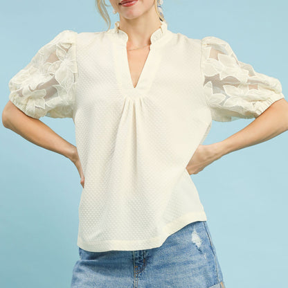 Lifestyle shot of the cream textured blouse with lace sleeves for an elegant outfit.