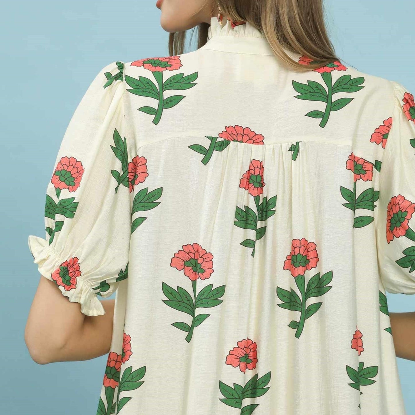 Close-up of the blouson sleeves and vibrant floral border print on the Umgee Cream Mix dress.