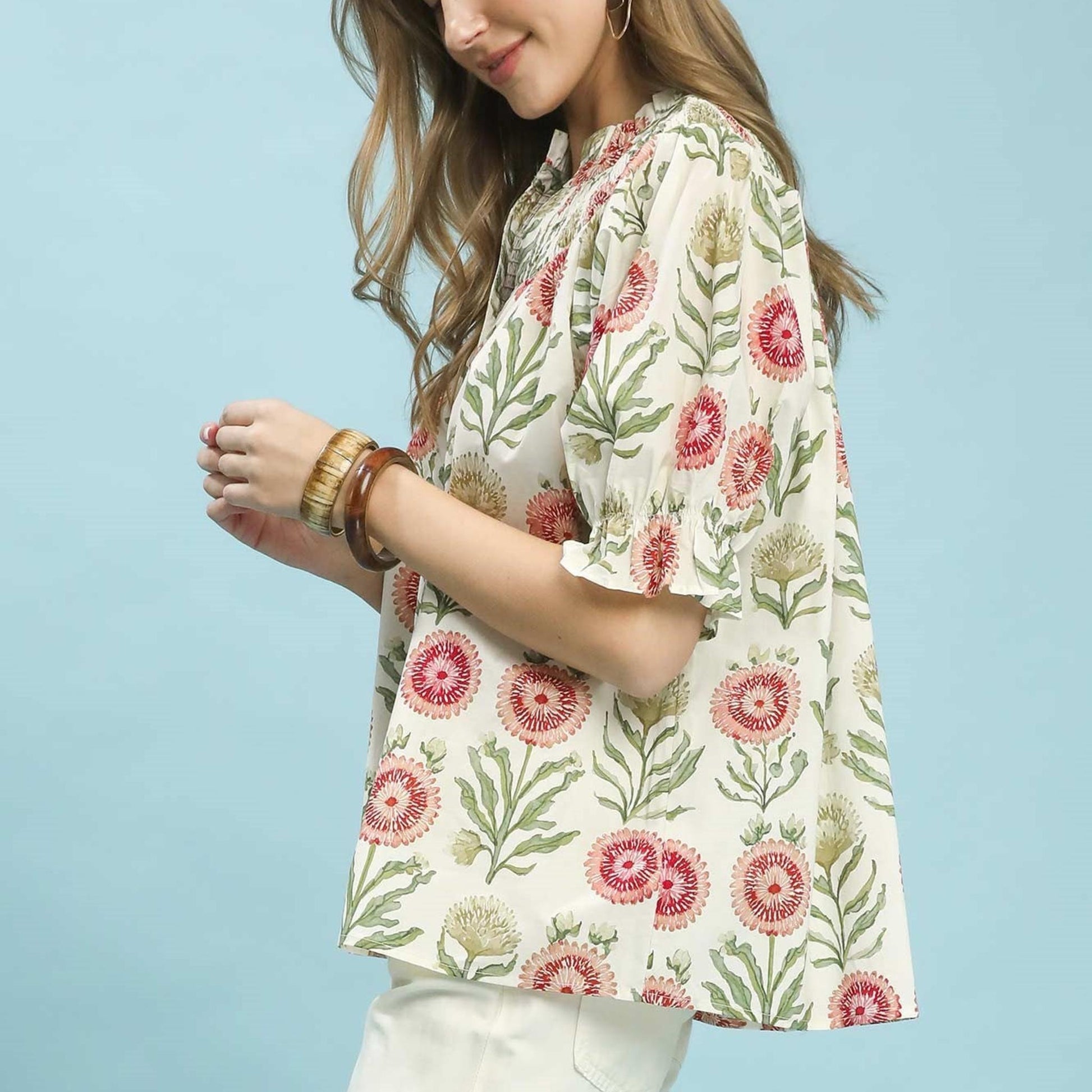 Full-length view of the Umgee red and green floral top showcasing the draped silhouette and hemline.