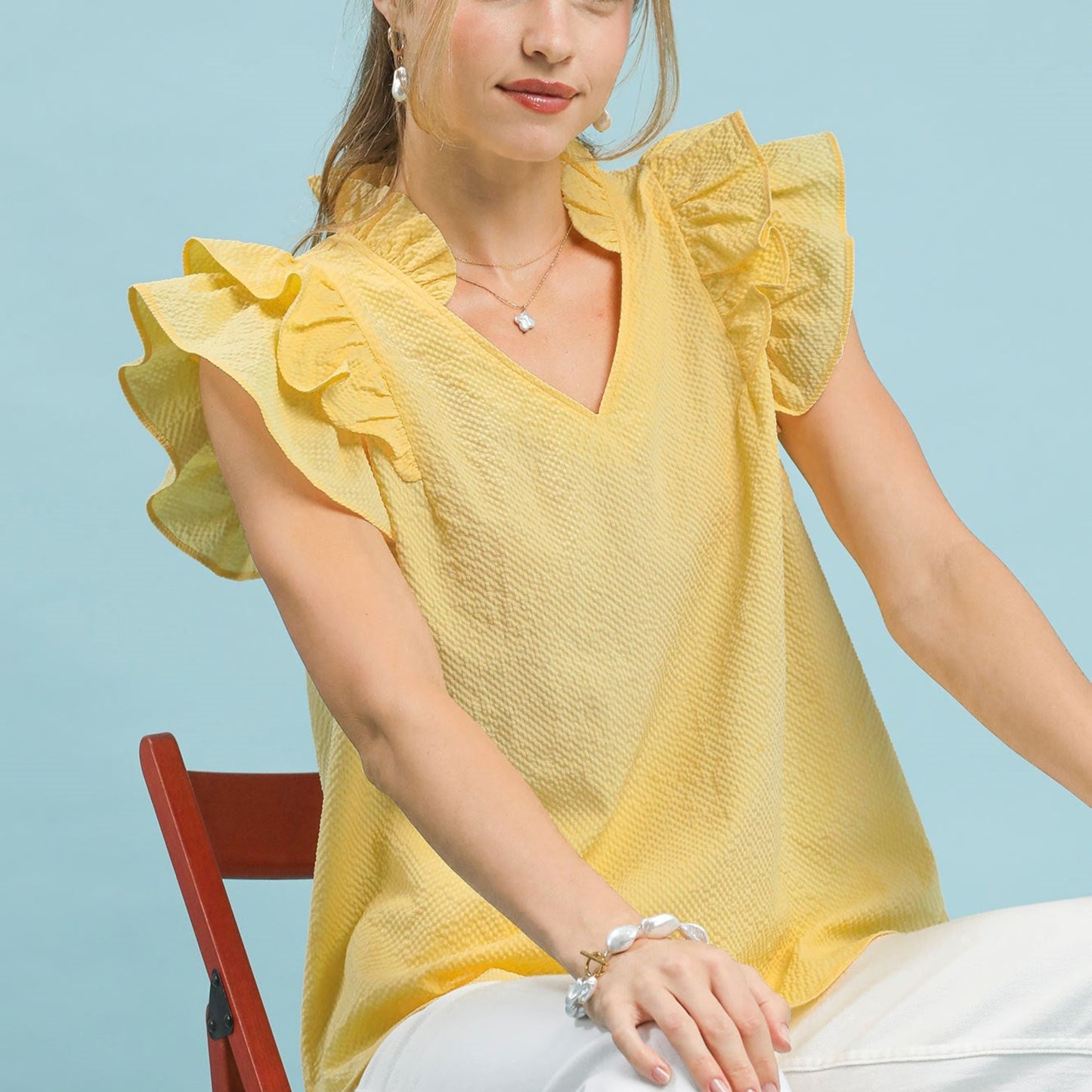 Front view of the Umgee textured ruffle sleeve V-neck blouse in ice lemon.