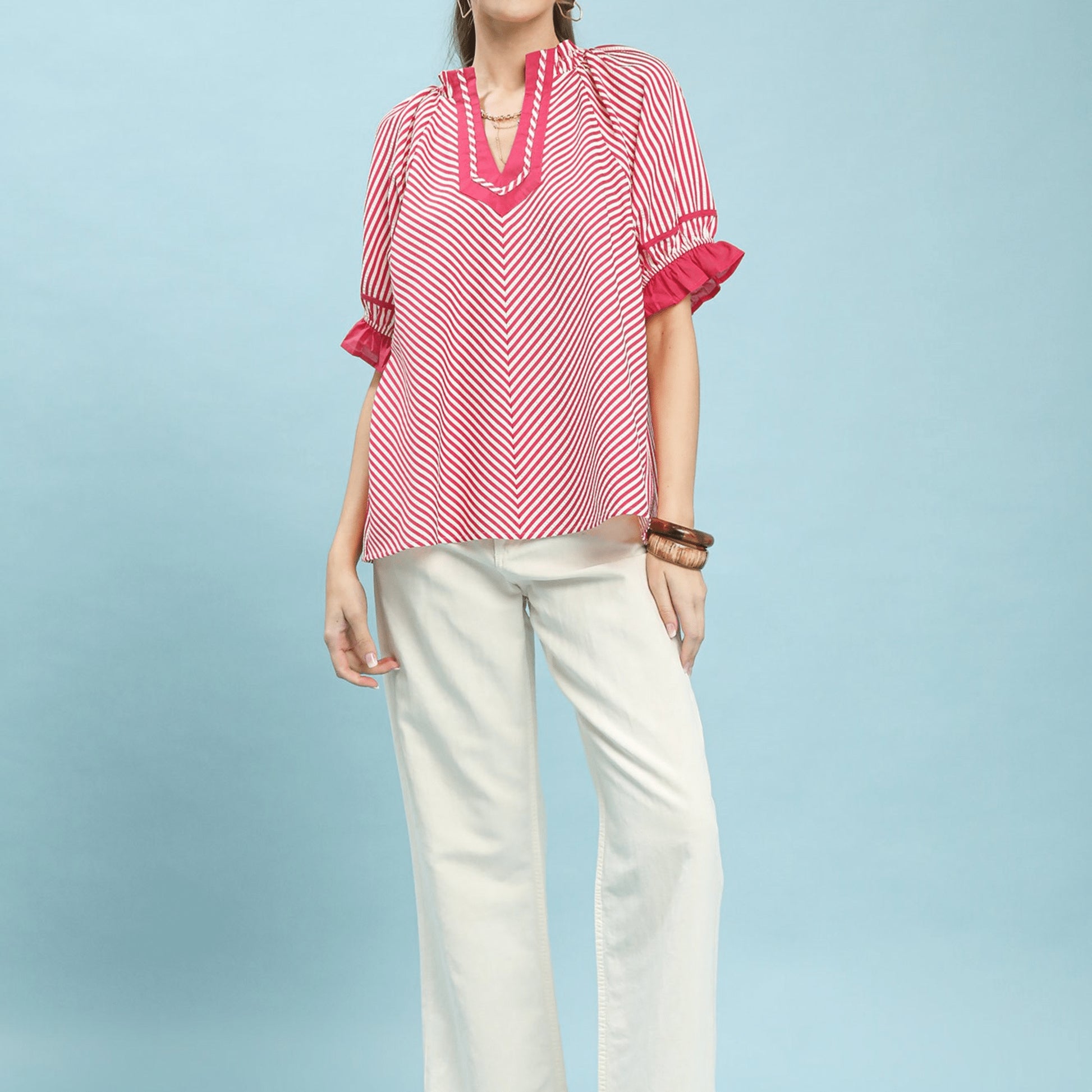 Lifestyle shot of the raspberry stripe ruffle sleeve blouse for a chic daytime look.