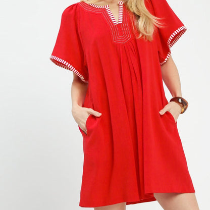 Side view highlighting the functional pockets and relaxed silhouette of the red Umgee mini dress.