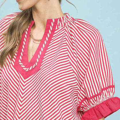 Detailed view of the feminine ruffle sleeves on the raspberry striped blouse.