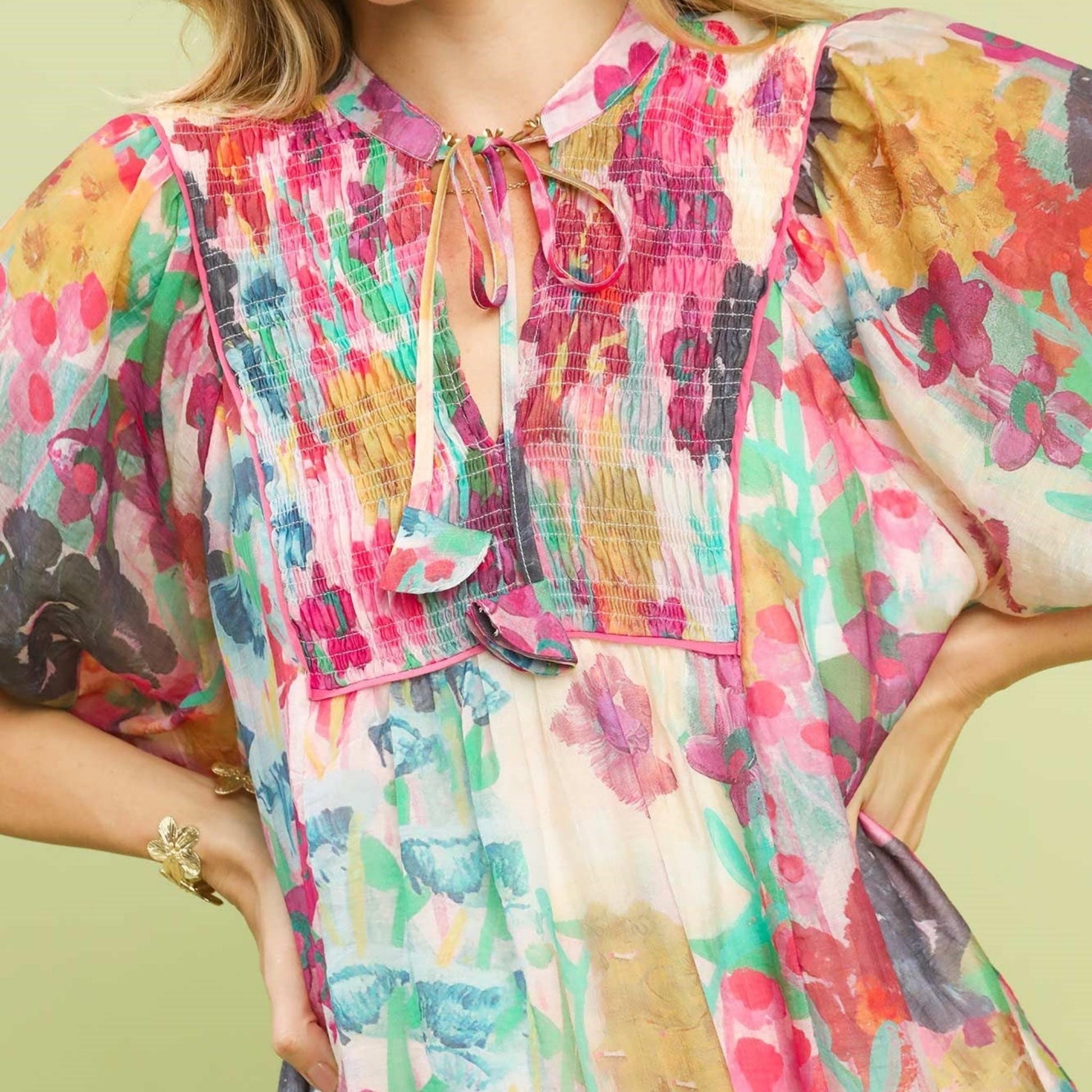 Close-up of the smocked V-neckline and contrast stitching on the floral Tencel dress.
