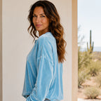 Side view of the women's sky blue Velvet Henley Sweatshirt highlighting the relaxed fit, long sleeves, and soft velvet fabric.