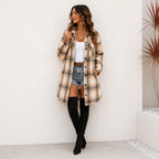 Woman wearing a khaki, brown and black plaid long cardigan shirt jacket with pockets