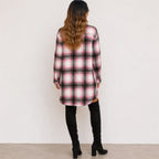 Back view of woman wearing a pink and black plaid long cardigan shirt jacket