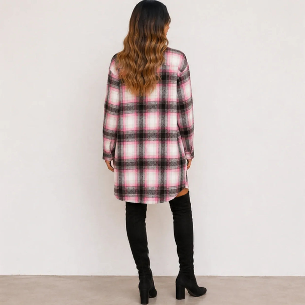 Back view of woman wearing a pink and black plaid long cardigan shirt jacket