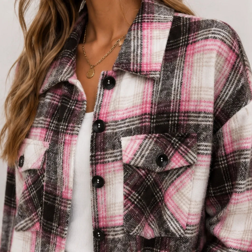 Close-up of pink and black plaid long cardigan shirt jacket showing button front and flap pockets