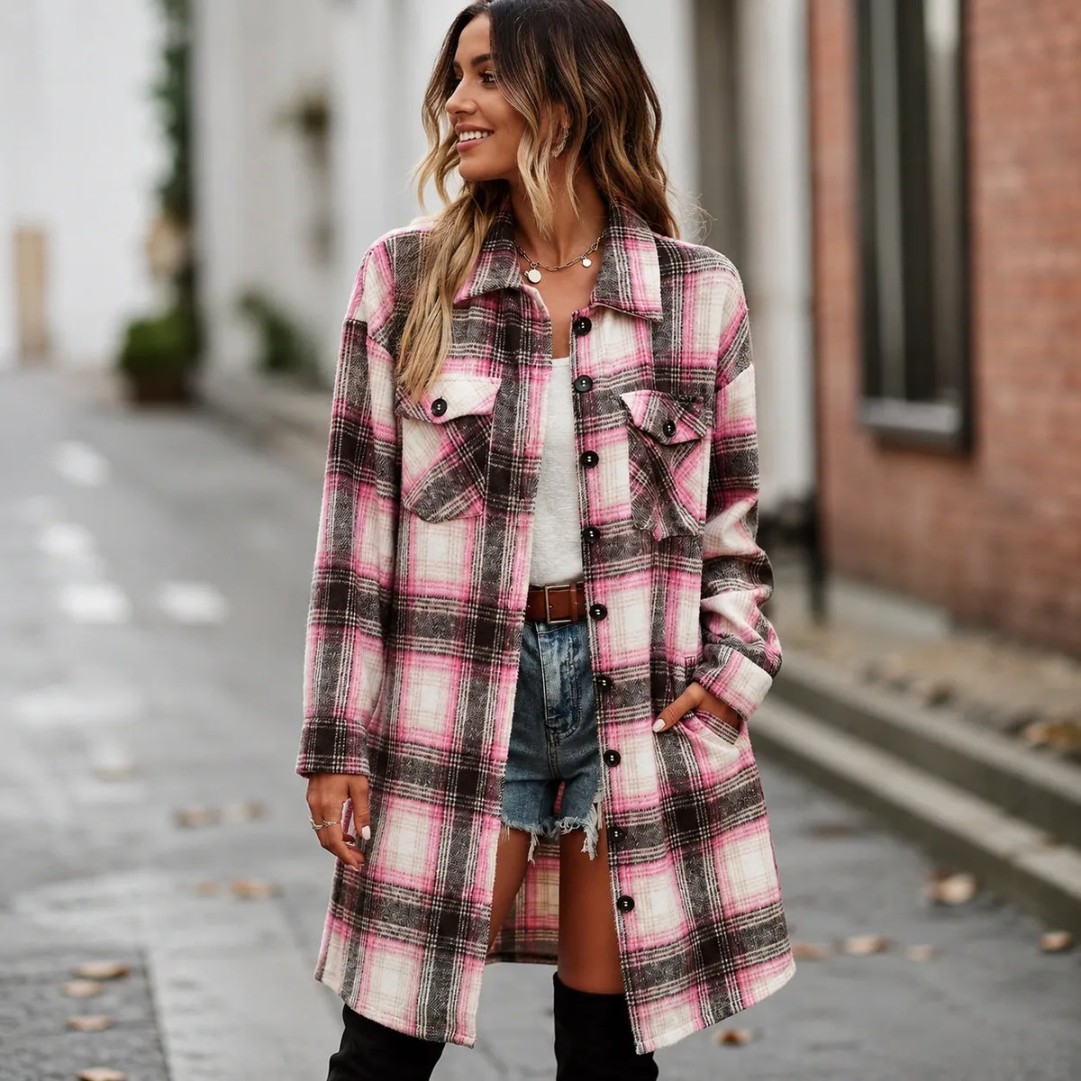 Woman wearing a pink and black plaid long cardigan shirt jacket with button front and pockets