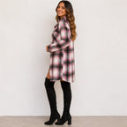Woman wearing a pink and black plaid long cardigan shirt jacket, side view