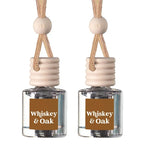 Two matching whiskey and oak car air fresheners with clear glass bottles, beige wooden diffusers, and braided rope hangers on a white background.