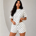 Woman wearing white short-sleeve top and matching lounge shorts set with black polka dots
