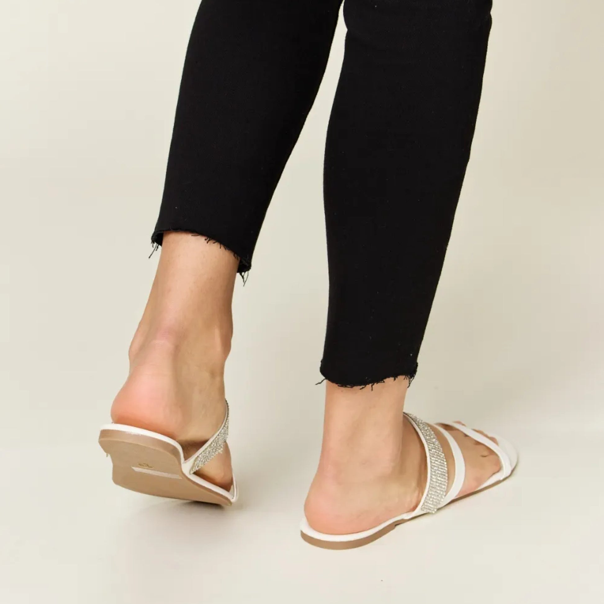 Back view of the low-profile white heel and secure strappy construction.