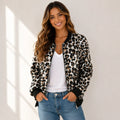 Woman wearing a black and tan leopard print bomber jacket with a white tank top and jeans