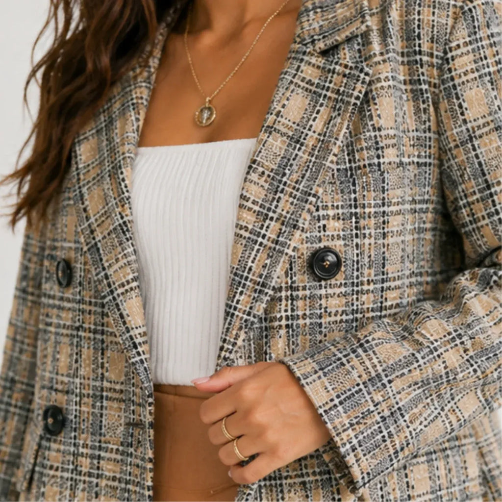 Close-up of women's grey and beige plaid double-breasted blazer showing textured plaid pattern and buttons