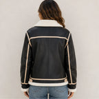 Back view of women's black faux shearling-lined leather jacket with cream contrast trim