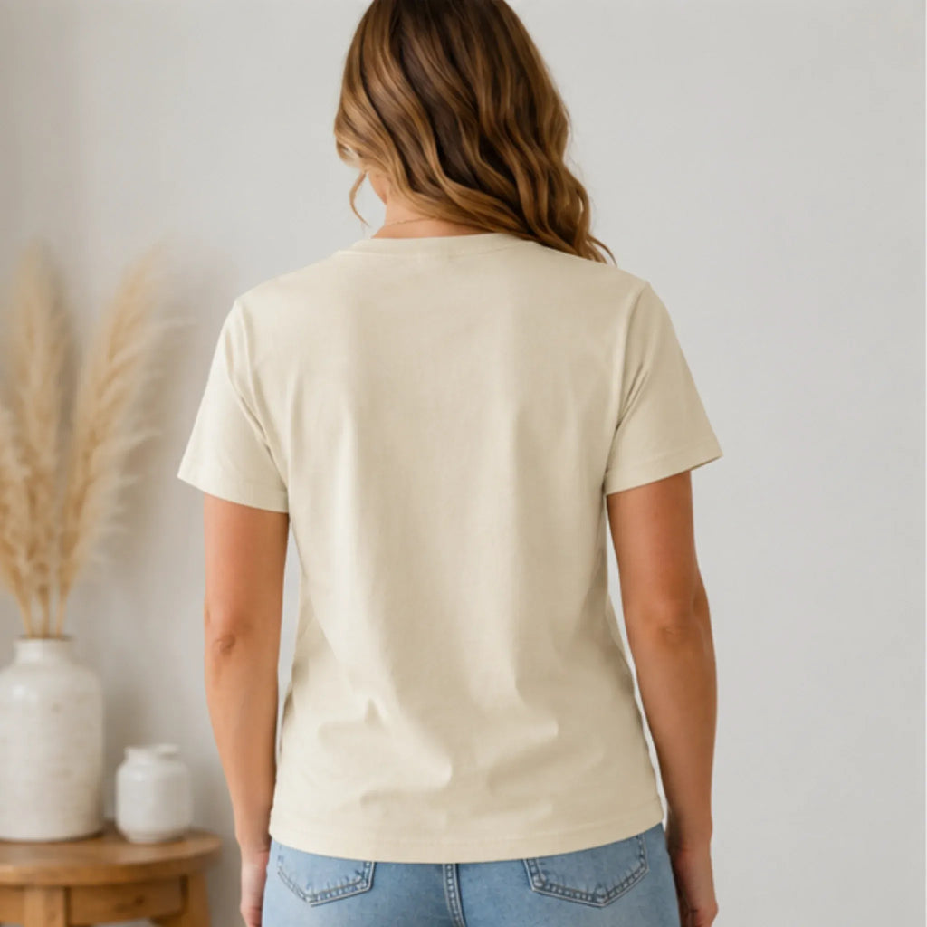 Back view of Women's Floral American Flag Graphic Tee in cream styled with light wash denim jeans.