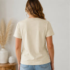 Back view of Women's Floral American Flag Graphic Tee in cream styled with light wash denim jeans.