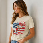 Side view of woman wearing Women's Floral American Flag Graphic Tee in cream featuring a patriotic floral flag print.