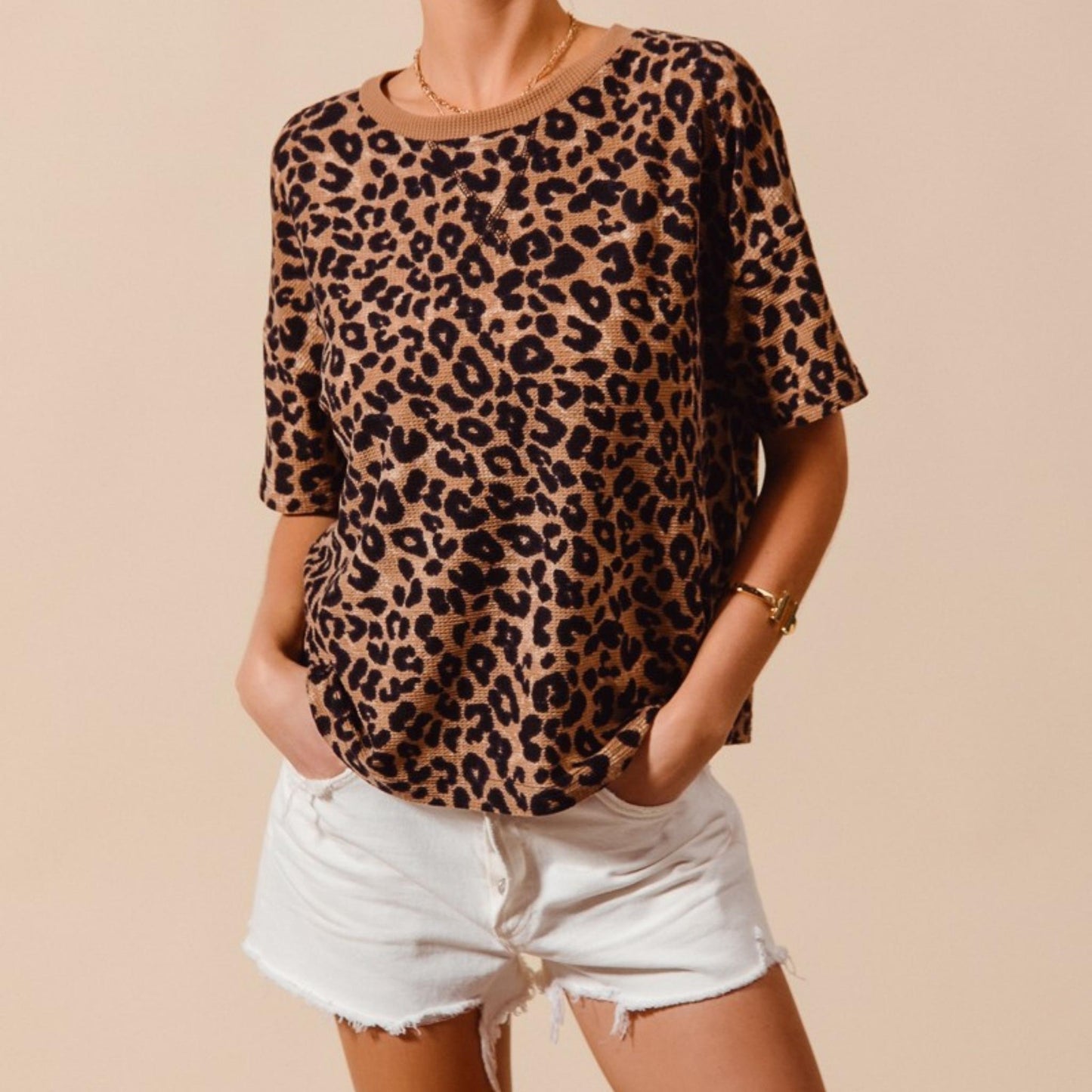 Full-length view of the oversized SO ME leopard print top styled with white shorts.